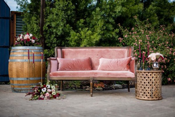 Mauve antique settee and wood carved side table.